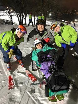 Tana takes a photo with her skiing volunteers at Hyland Hills