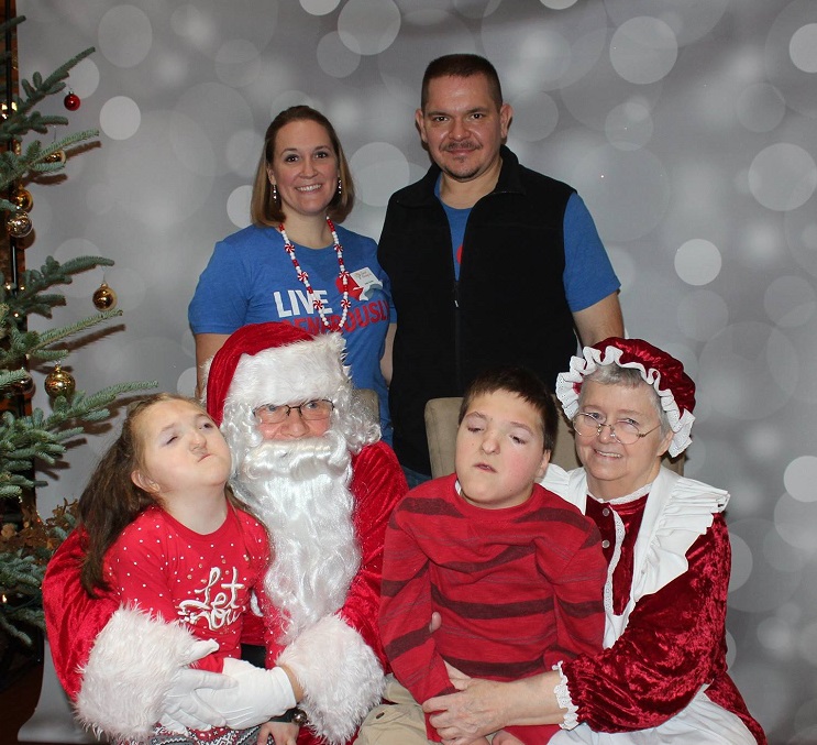 Annie, Chris, Zak, and Callie get a family photo with Santa and Mrs. Claus